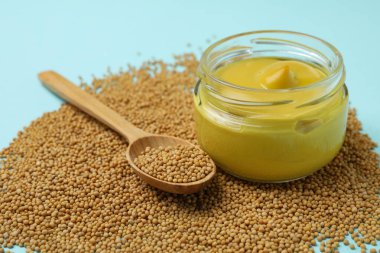 Hardallı kavanoz ve mavi arka planda tohumlu kaşık.