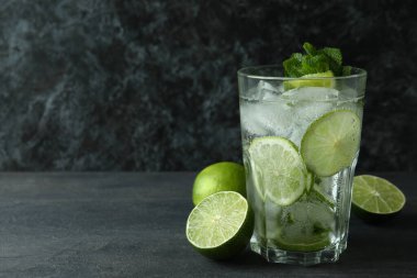 Bir bardak mojito kokteyli ve koyu ahşap masa malzemesi.