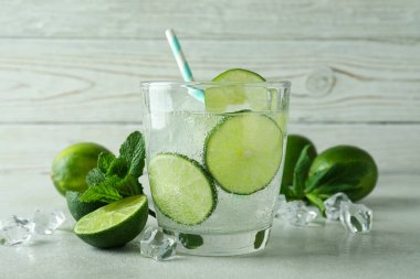 Bir bardak mojito kokteyli ve ahşap arka plana karşı malzemeler.