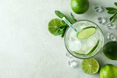 Bir bardak mojito kokteyli ve beyaz desenli arka plan malzemeleri.