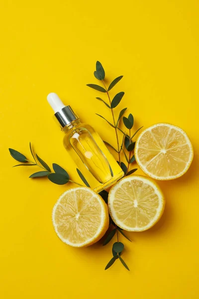 Concept of natural cosmetics with lemon oil on yellow background