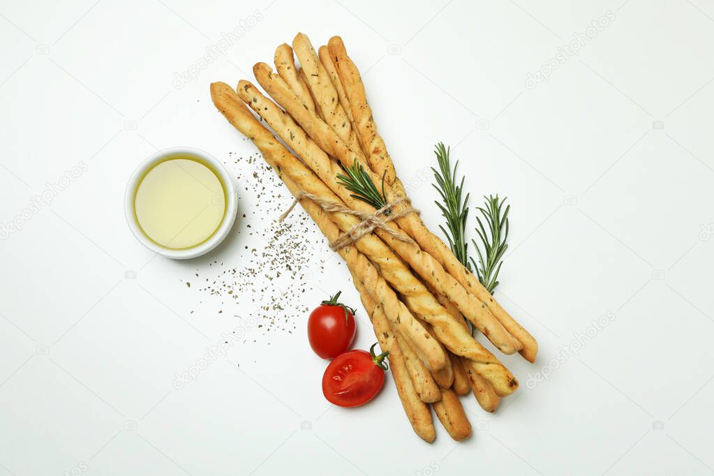 Grissini breadsticks with spices on white background
