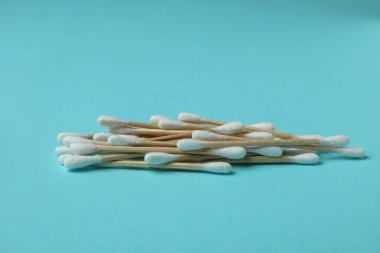 Mavi arkaplanda ahşap pamuk çubukları, metin için boşluk