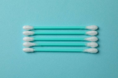 Mavi arkaplanda plastik pamuklu çubuklar, kapatın.