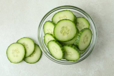 Beyaz desenli arka planda salatalık dilimleri olan bir kase