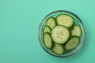 Nane arkaplanda olgun salatalık dilimleri olan bir kase.