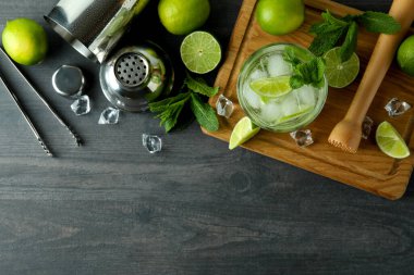 Bir bardak mojito kokteyli ve malzemelerle dolu bir pano.
