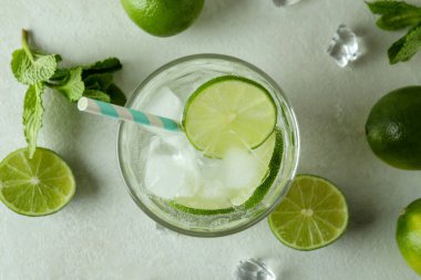 Bir bardak mojito kokteyli ve beyaz desenli arka plan malzemeleri.