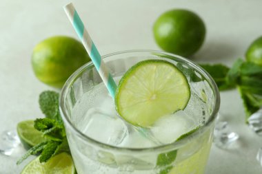 Bir bardak mojito kokteyli ve beyaz desenli arka plan malzemeleri.