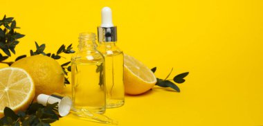 Sarı zemin üzerinde limon yağı olan doğal kozmetik kavramı