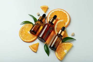 Beyaz arka planda yağ ve portakal dilimleri olan damlalar.