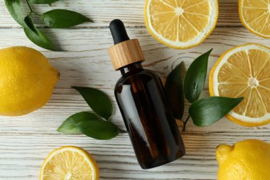 Beyaz ahşap masada yağlı ve limonlu bir şişe.