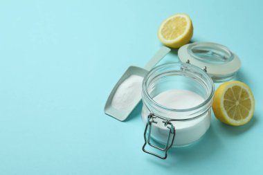 Mavi arka planda asit tozu ve yarım limon ile kepçe ve kavanoz