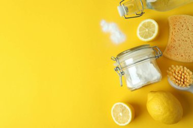 Çevre dostu temizlik araçları ve sarı arka planda limonlar ile temizlik kavramı