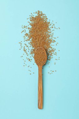 Mavi arka planda hardal tohumlu ahşap kaşık