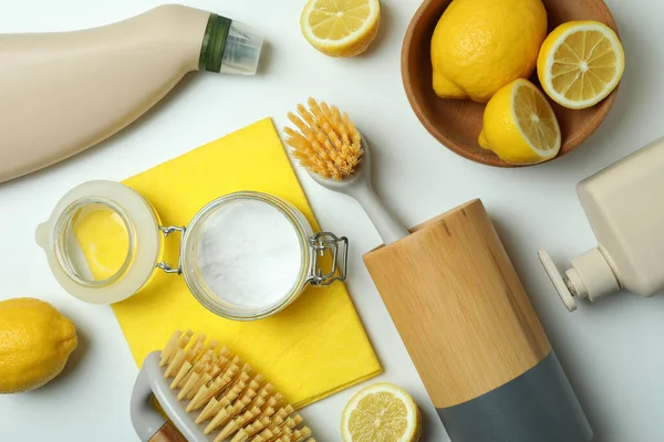 Cleaning concept with eco friendly cleaning tools and lemons on white background