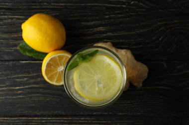 Bir bardak zencefil - limon suyu ve ahşap masadaki malzemeler