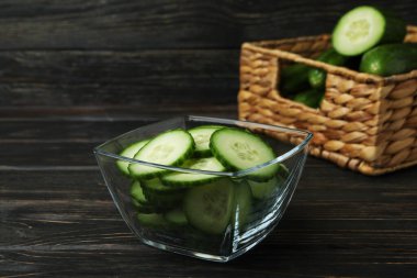 Tahta arka planda olgun salatalıklı kase ve sepet.