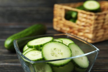 Tahta arka planda olgun salatalıklı kase ve sepet.