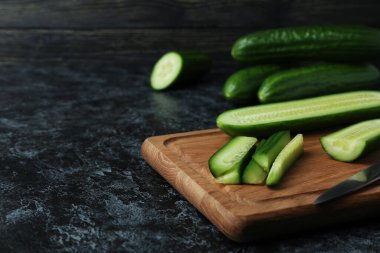 Olgun salatalık ve siyah dumanlı masada bıçak.