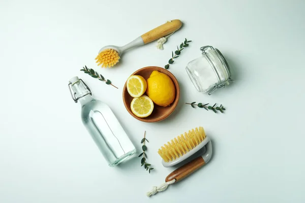 Cleaning concept with eco friendly cleaning tools and lemons on white background