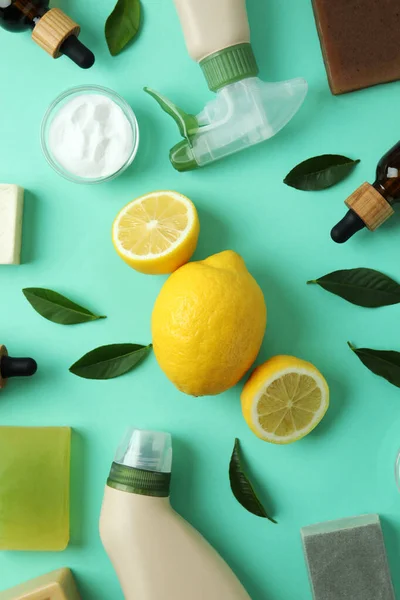 Cleaning concept with eco friendly cleaning tools and lemons on mint background