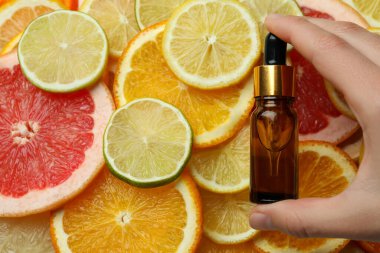 Kadın el ele tutuşma şişesi, farklı narenciye dilimlerinde yağlı.