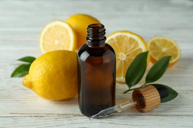 Beyaz ahşap masada yağlı ve limonlu bir şişe.