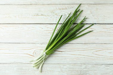 Beyaz ahşap zemin üzerinde taze yeşil soğan