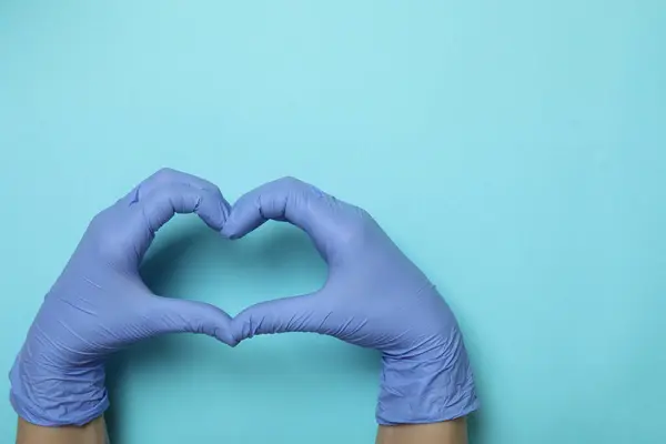 Manos Guantes Médicos Muestra Corazón Sobre Fondo Azul —  Fotos de Stock