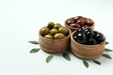 Beyaz arka planda tahtadan zeytin kaseleri ve yapraklar