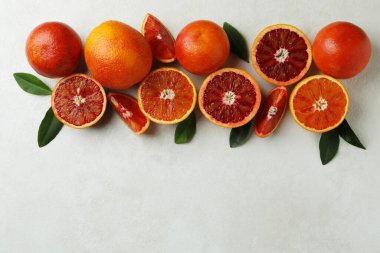 Beyaz arkaplanda kırmızı portakallar ve yapraklar