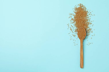 Mavi arka planda hardal tohumlu ahşap kaşık