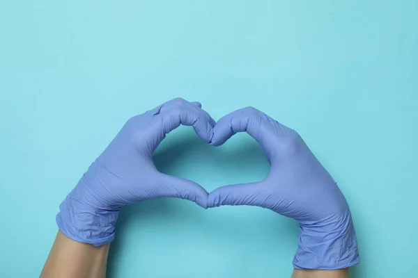 Manos Guantes Médicos Muestra Corazón Sobre Fondo Azul —  Fotos de Stock