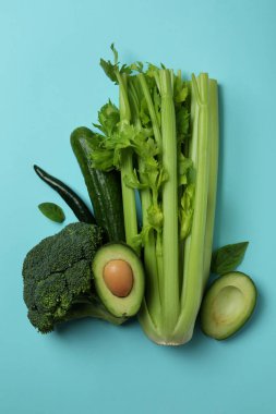 Mavi arka planda bir grup taze yeşil sebze.
