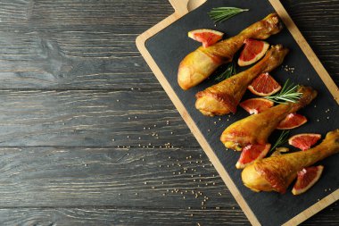 Ahşap arka planda tavuk budu kızartma tahtası.