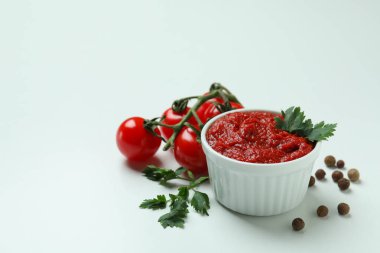 Beyaz arka planda domates, biber ve maydanozlu kase.