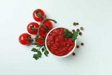 Beyaz arka planda domates, biber ve maydanozlu kase.