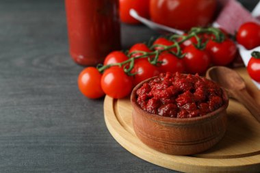 Koyu ahşap masaya domates ezmesi ve malzemelerle dolu bir kase.