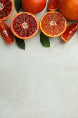 Beyaz arkaplanda kırmızı portakallar ve yapraklar