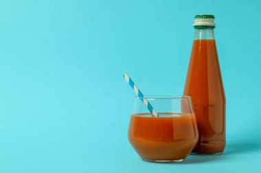 Mavi arka planda bir şişe meyve suyu.