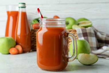 Elma - havuç suyu ve malzemeler beyaz desenli masa üzerinde