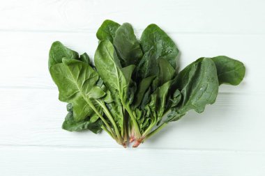 Beyaz ahşap arka planda taze çiğ ıspanak.