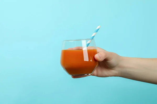 Weibliche Hand Hält Glas Saft Auf Blauem Hintergrund — Stockfoto