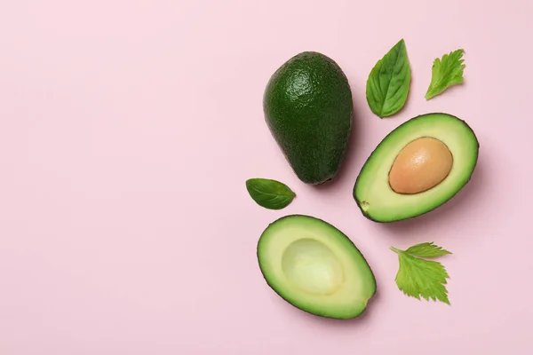 Grüne Avocado Und Blätter Auf Rosa Hintergrund — Stockfoto