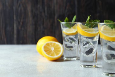 Limonlu shot ve beyaz desenli masada nane şekeri.