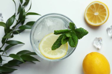 Beyaz arka planda limonlu bir bardak kokteyl.