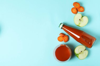 Mavi arka planda bir şişe meyve suyu ve malzeme var.