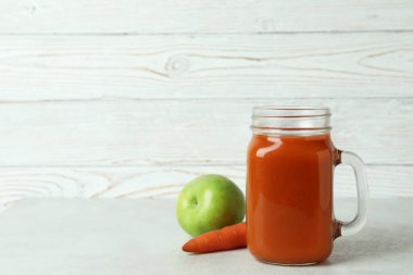 Cam kavanoz meyve suyu ve malzemeler beyaz ahşap arka plana karşı