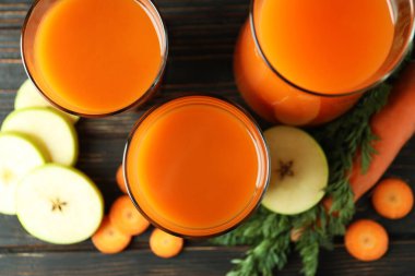 Bardaklar ve sürahi, meyve suyu ve ahşap arka planda malzemeler.